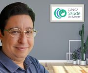 Roger, Psicanalista, homem de pele clara, cabelos curtos e escuros, com óculos pequenos, um leve sorriso e camisa azul.